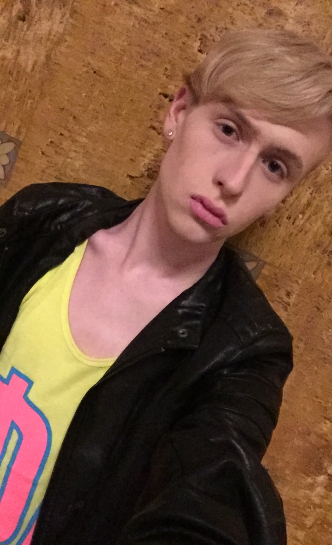 image of matt reese wearing a black leather jacket and a bright yellow and pink top
