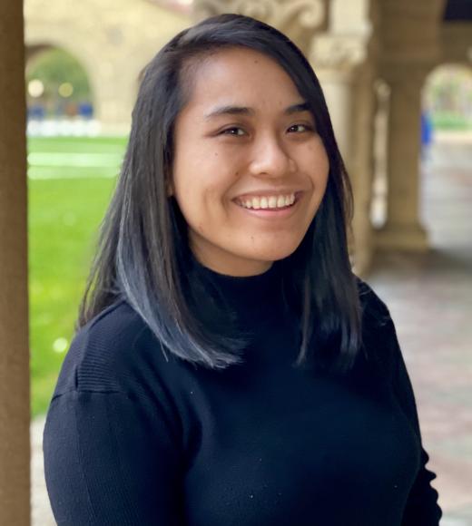 Athena wearing black in front of campus background
